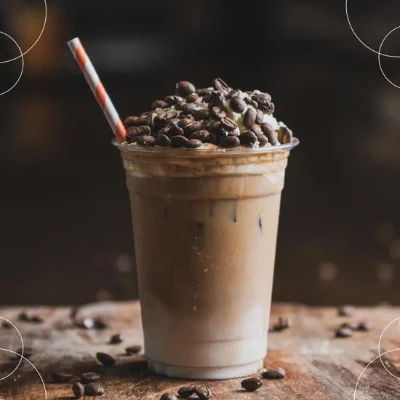 Frappé de café helado con crema batida en vaso con popote